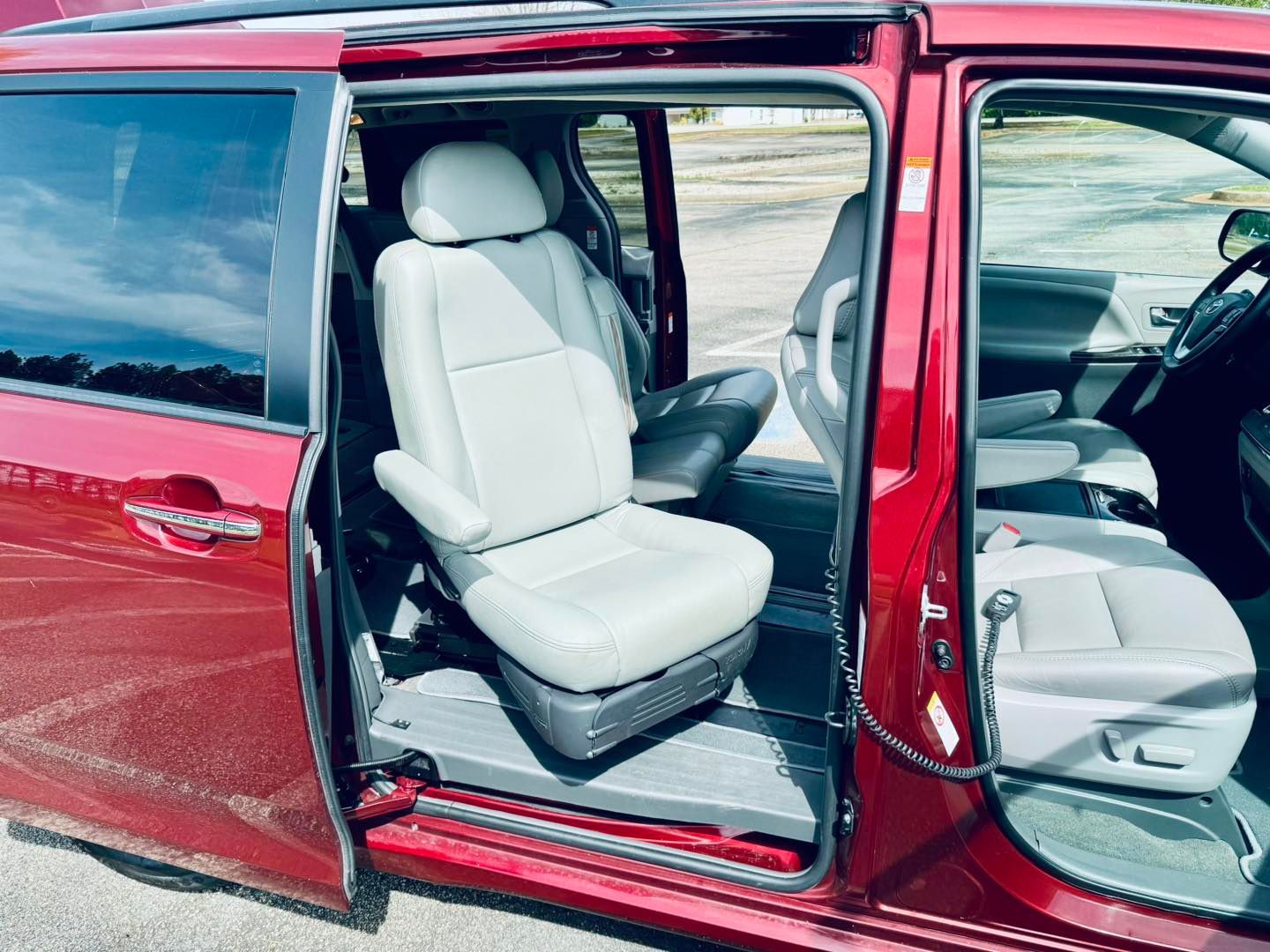 Red minivan interior with opened side door and accessible seating.