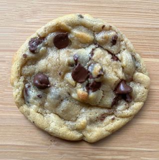Chocolate chip cookie on a wooden surface.