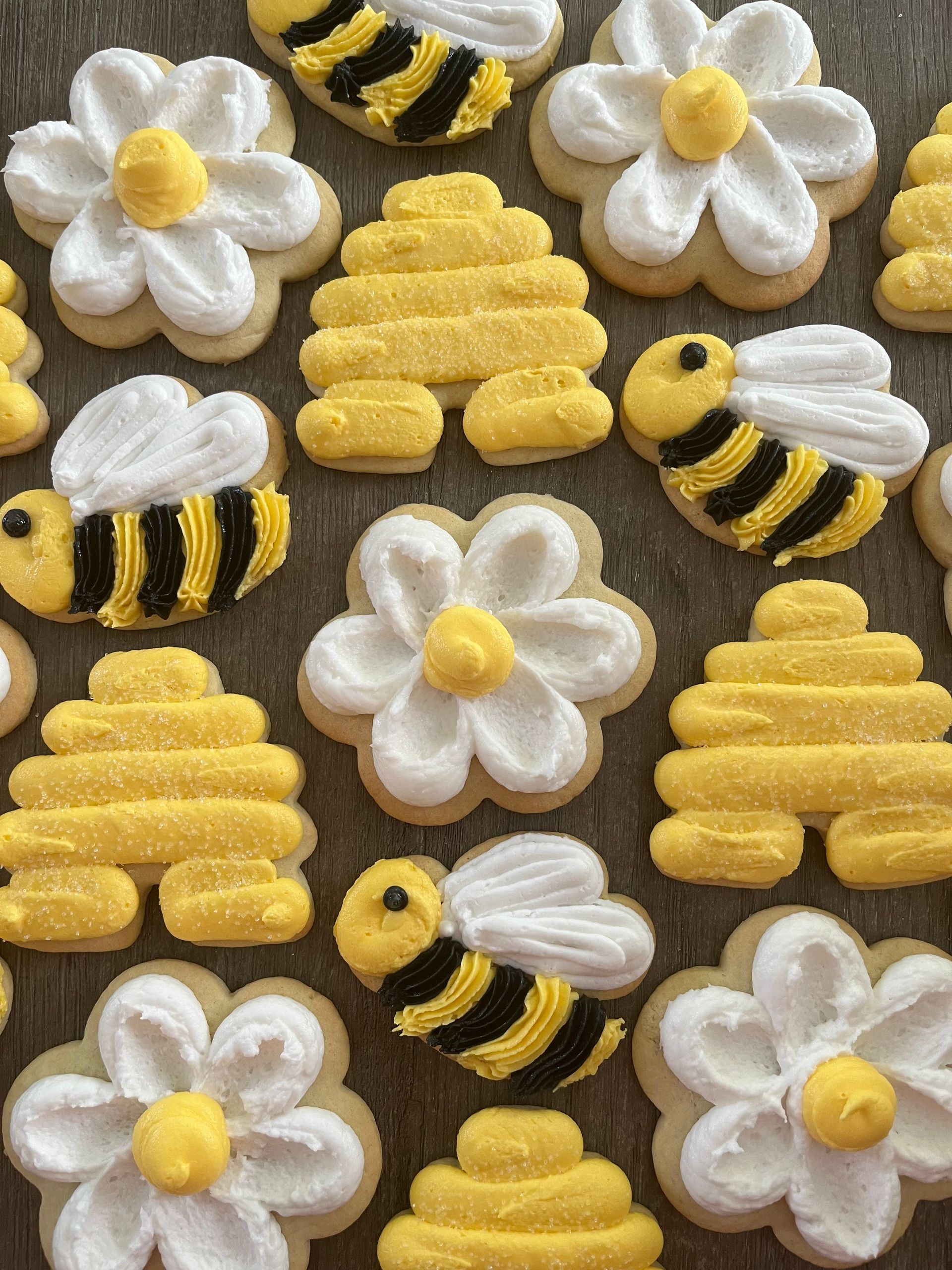 a bunch of cookies decorated to look like bees and flowers on a table