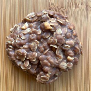 Chocolate-coated nut cluster on a wooden cutting board