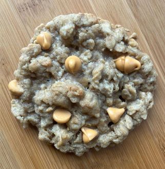 Round peanut-studded oatmeal cookie on a wooden surface