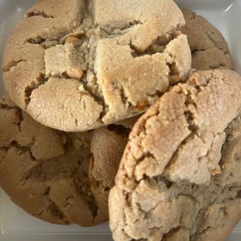 Stack of cracked, golden-brown cookies on a white background