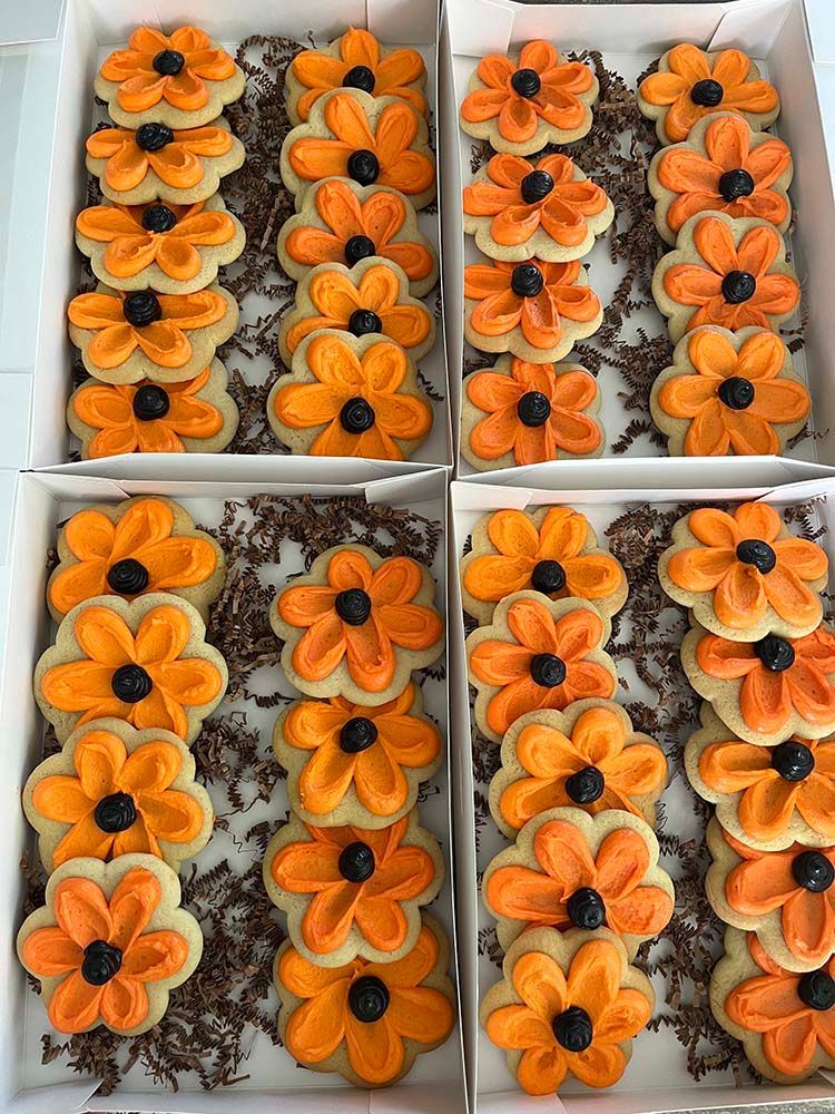 a box of cookies decorated to look like orange flowers