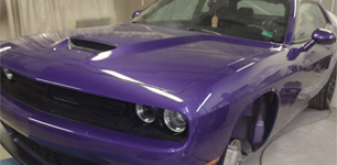 Learn more about Services Purple Dodge Challenger parked indoors in a garage, front-left view