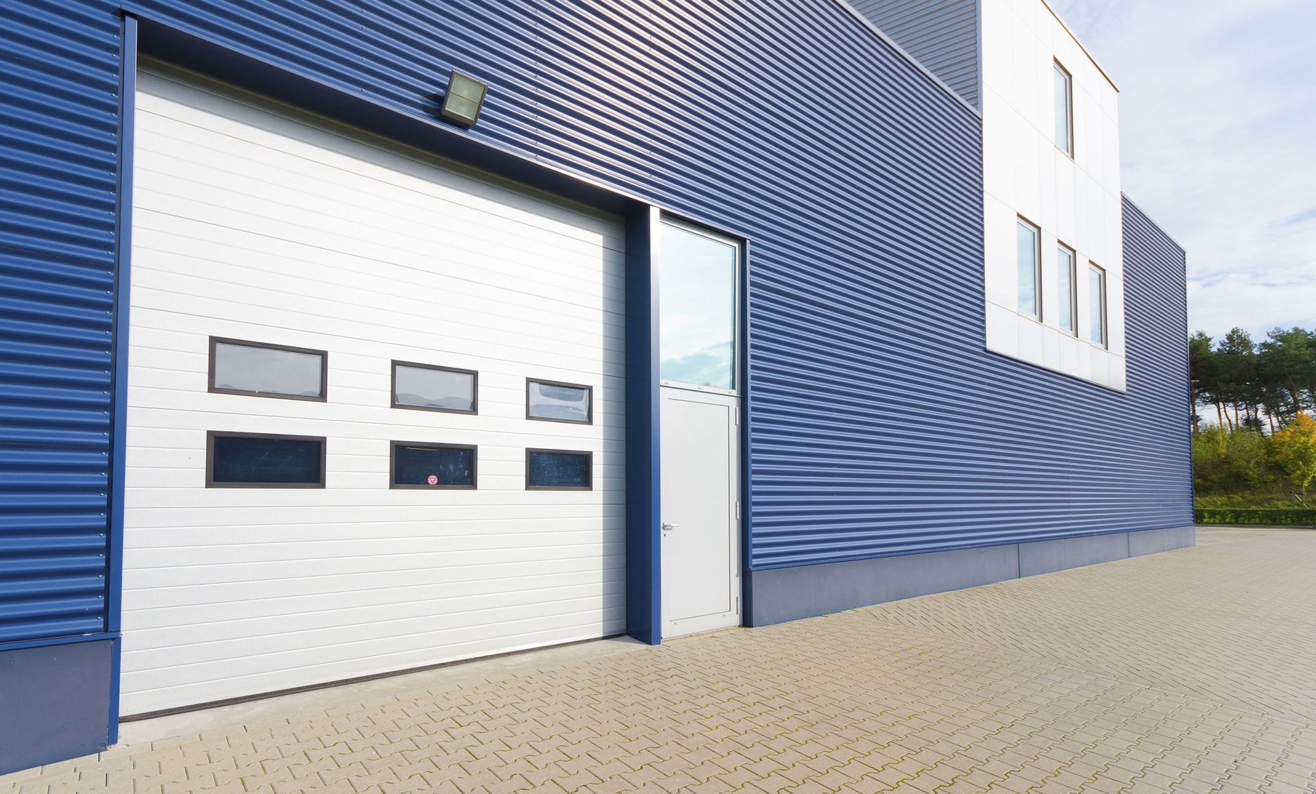 A blue and white building with a white garage door