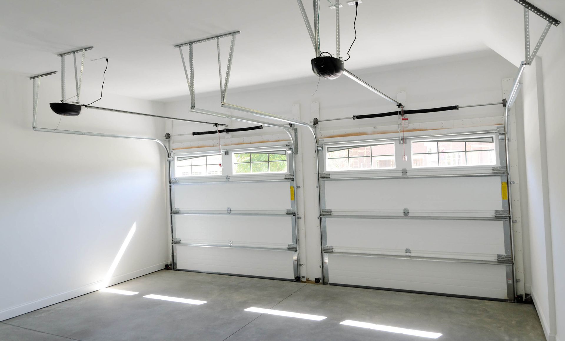 An empty garage with two garage doors.