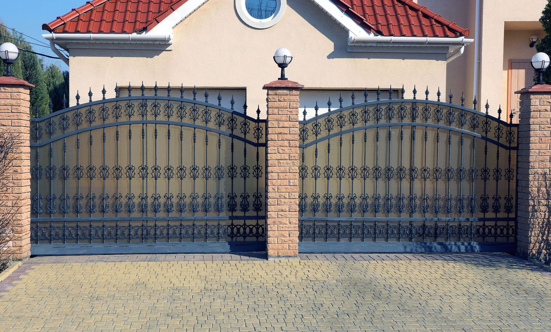 A house with a red roof and a wrought iron gate