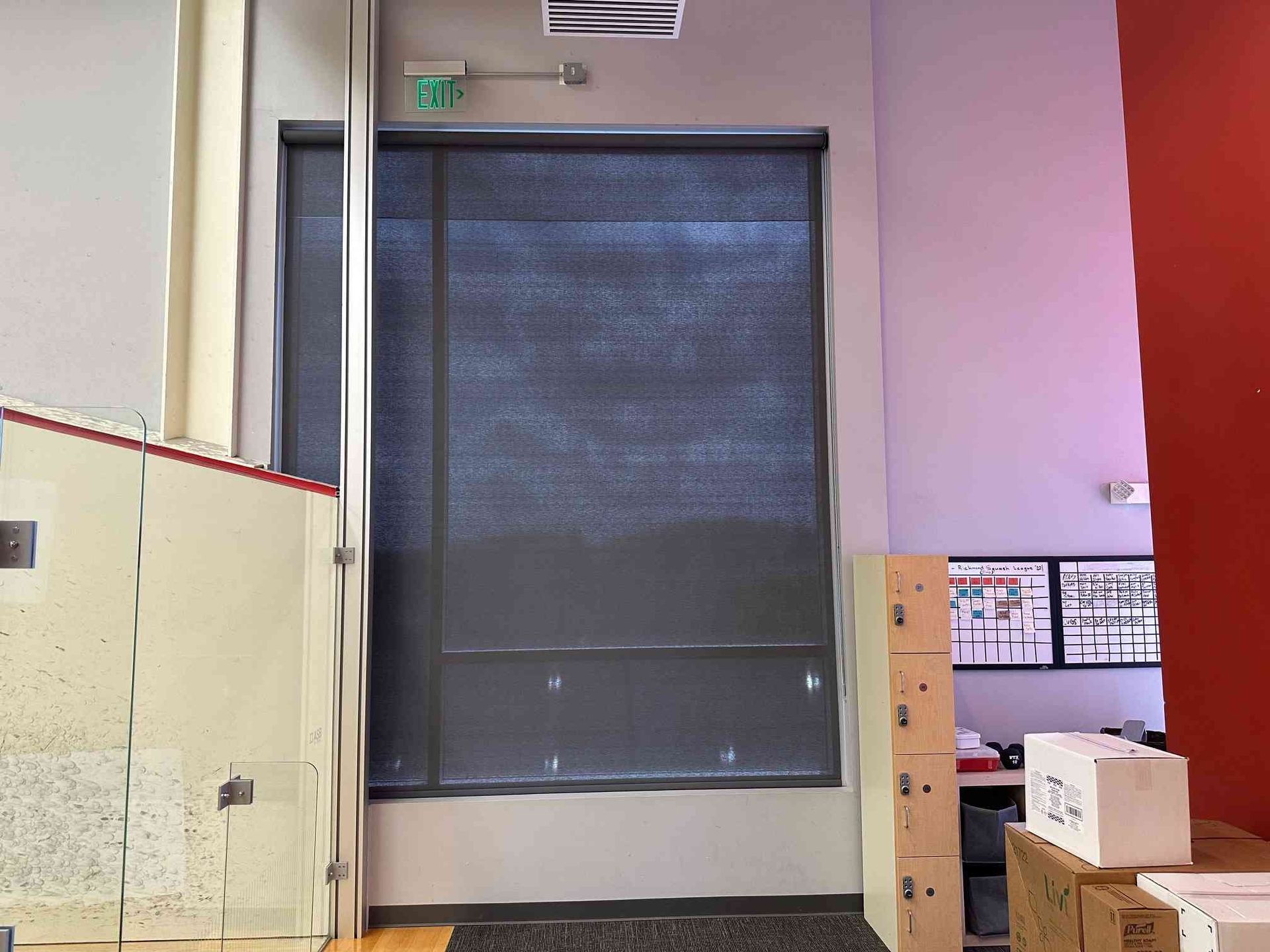 Industrial interior with a closed roll-up door, wall notices, and stacked boxes on the right