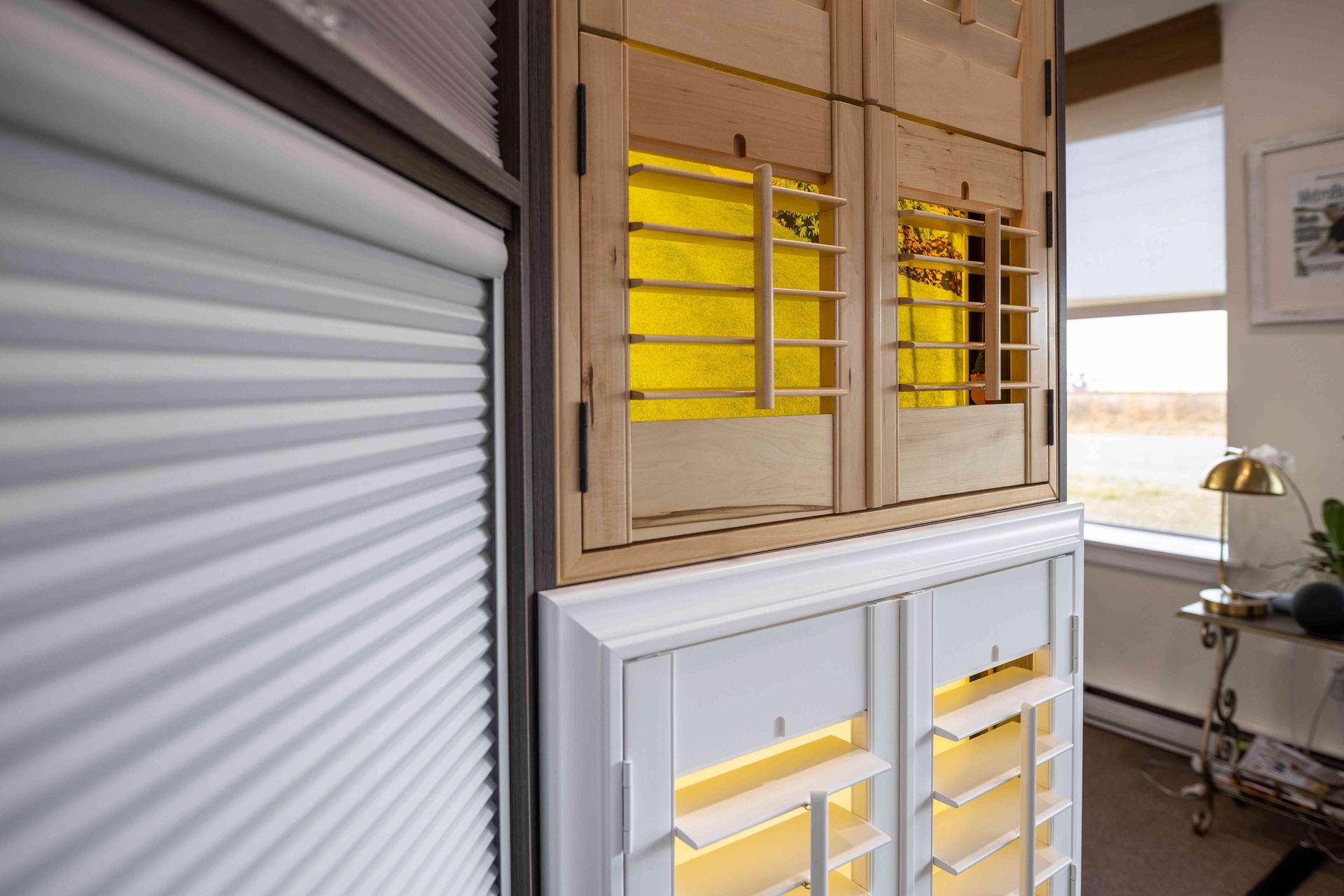 White and tan louvered cabinets with yellow glass panels in a bright interior room