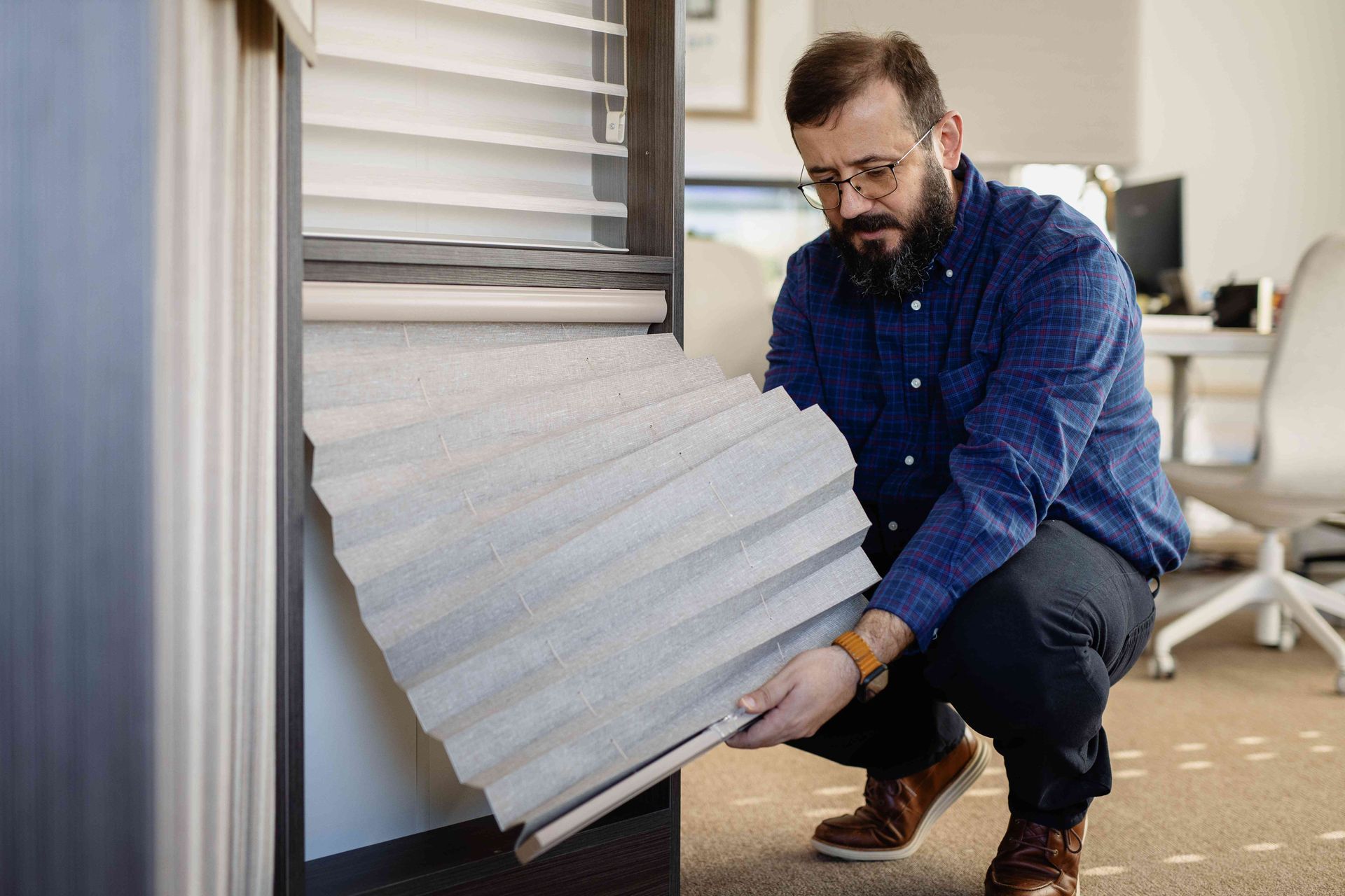Man kneels by an RV, adjusting a white corrugated panel near the side wall.