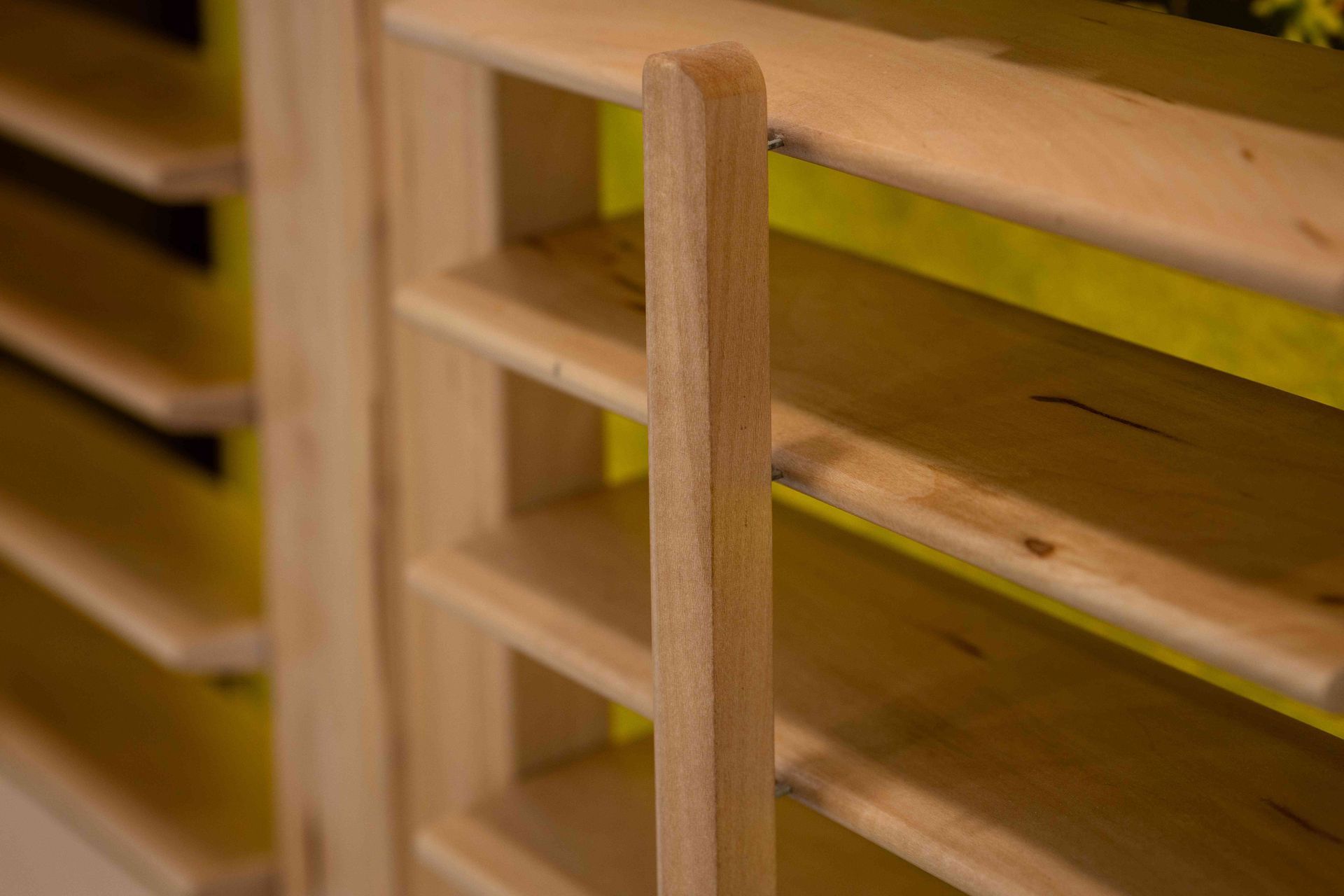 Close-up of a wooden ladder or slatted frame against a yellow background