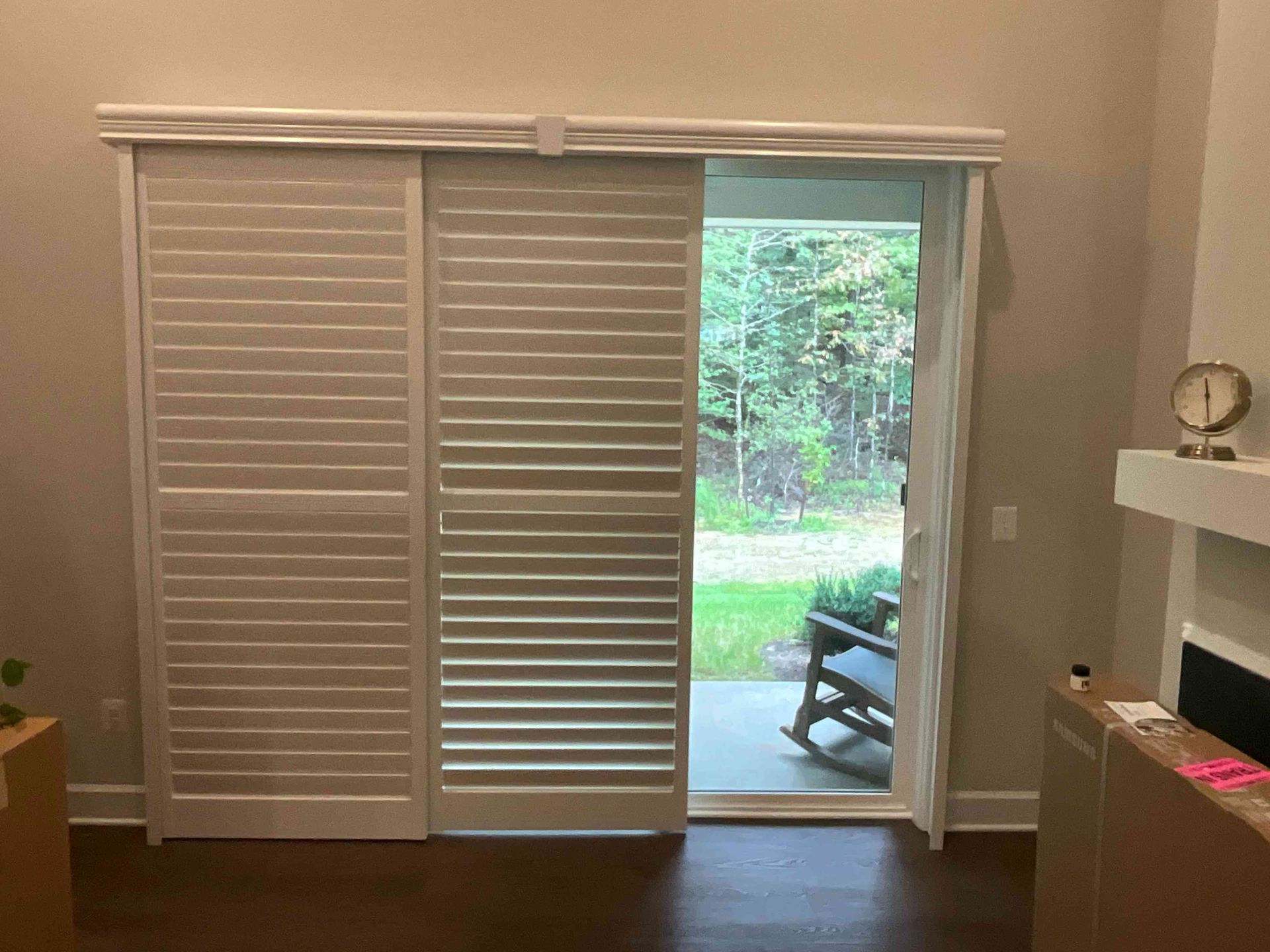 Living room with white sliding closet doors open to a patio and green yard beyond.