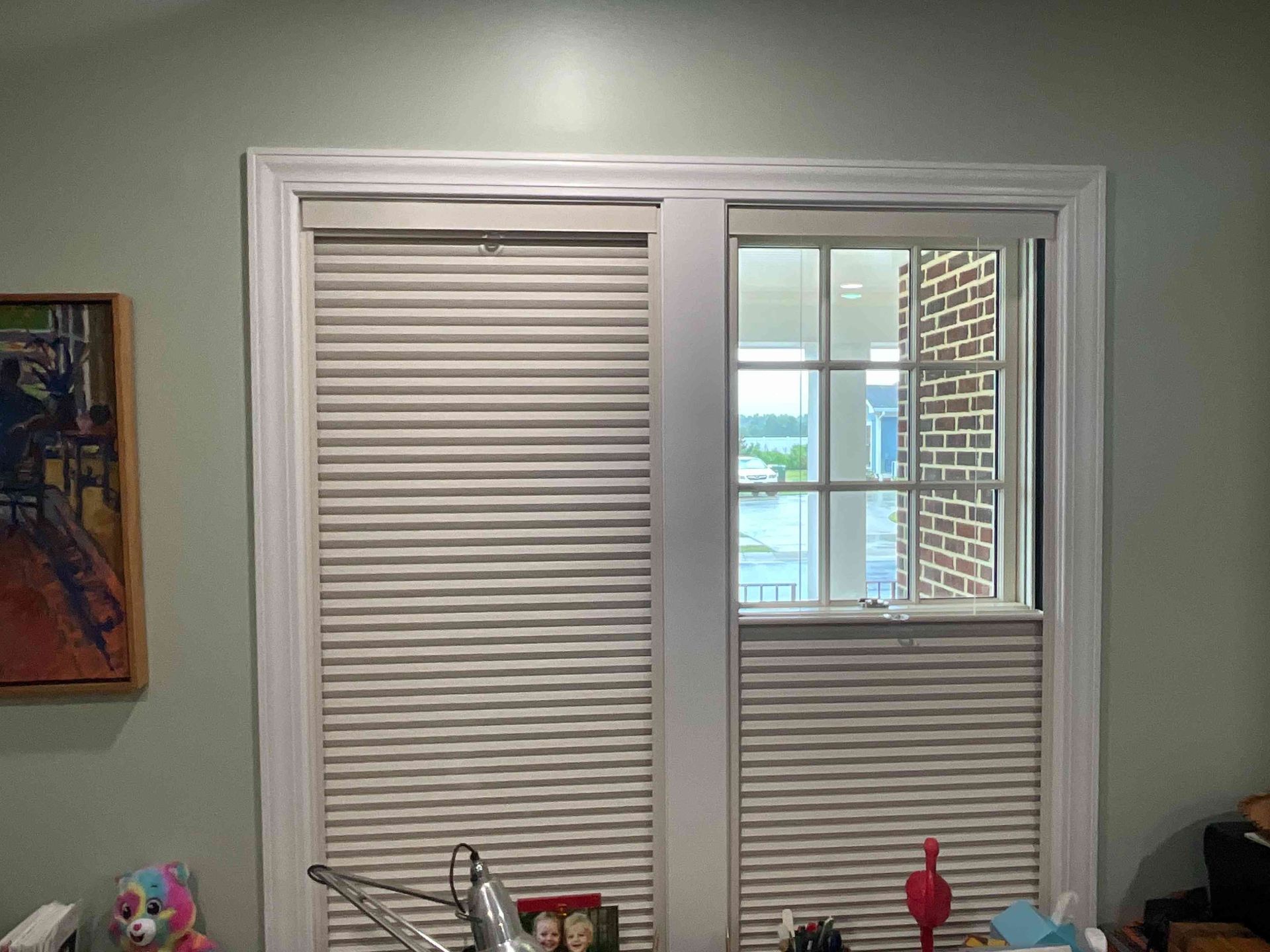 Kitchen window with closed blinds, a small open pane, and a sink below it