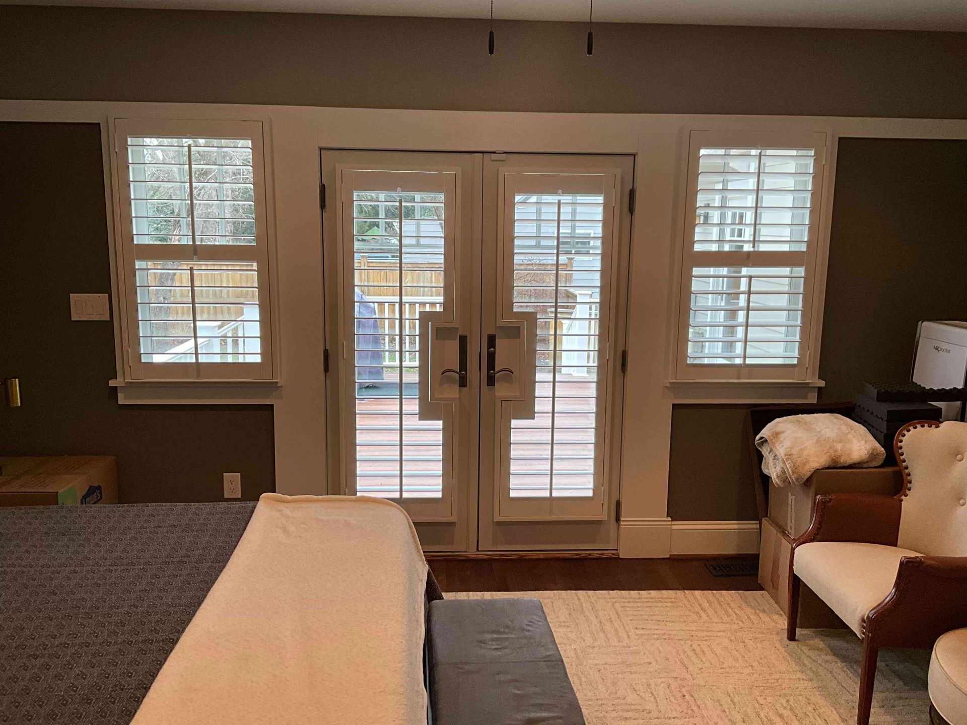 Living room with French doors, windows, and a sofa and chair on the right