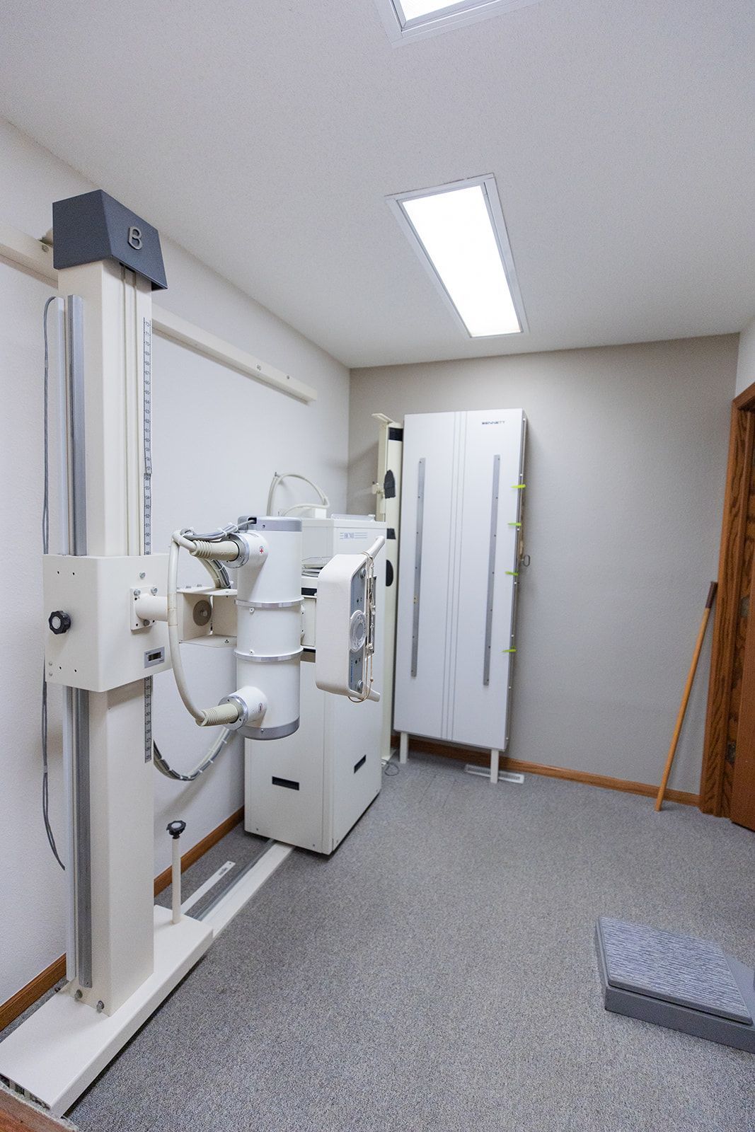 An x-ray machine is sitting in a room next to a door