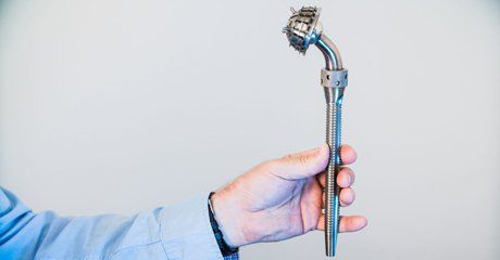 Closeup of a modern hip implant in the doctor's hands.