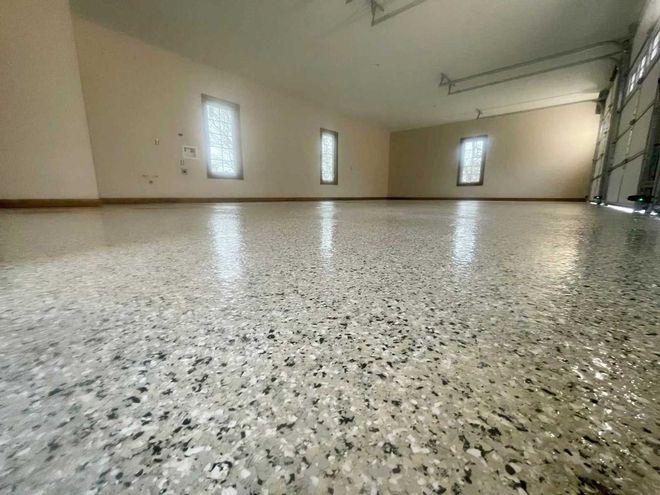 Garage with a glossy, speckled floor and three windows.