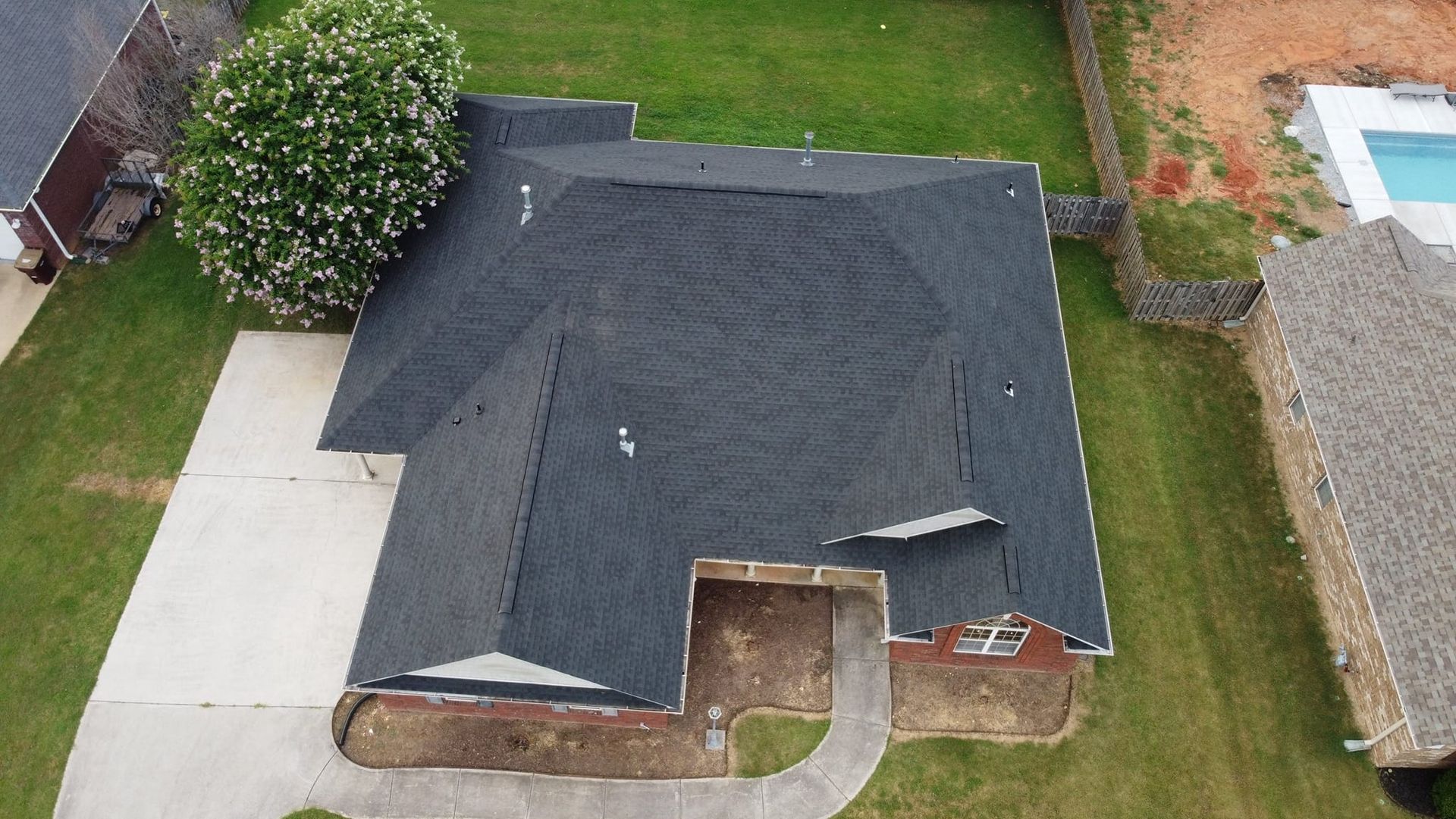 An aerial view of a house with a black roof.