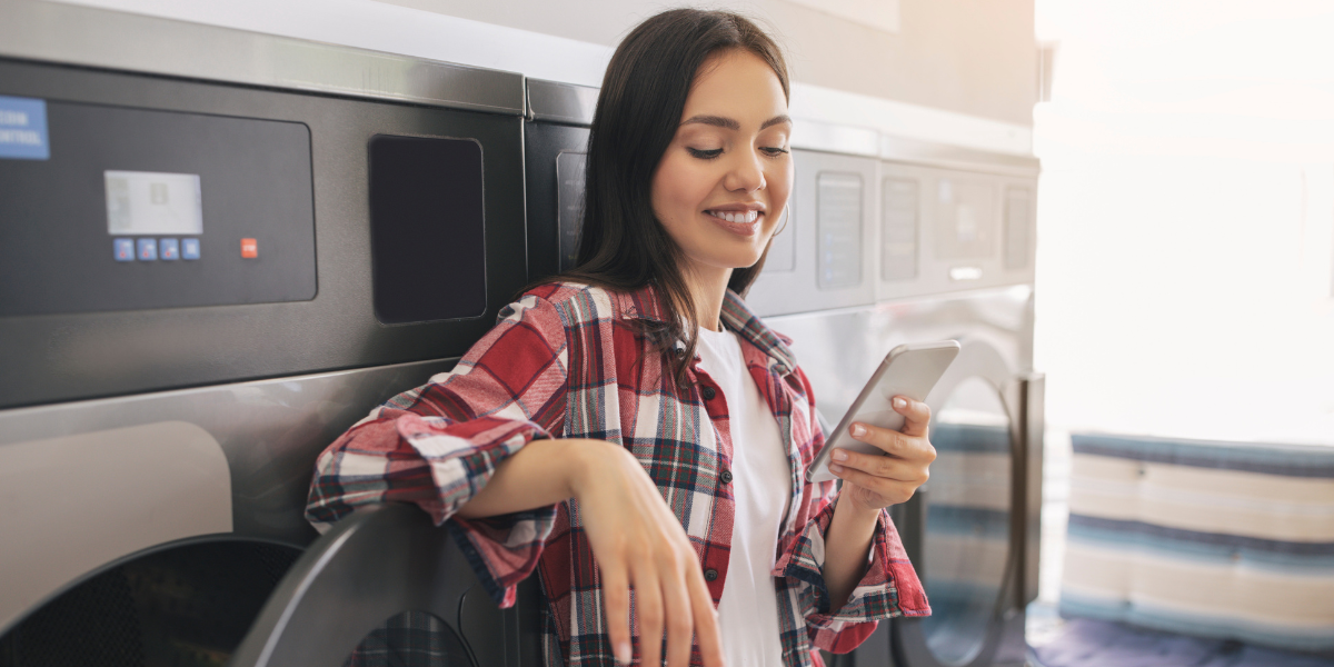 young lady using a laundry payment app called clear token on her phone