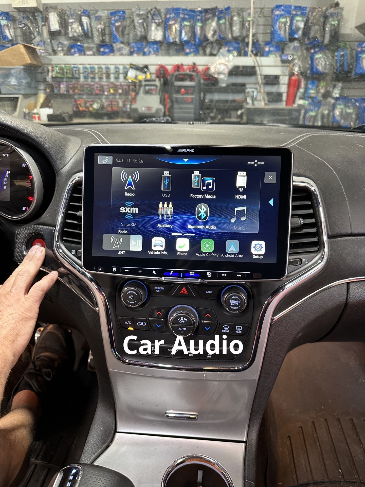 A person is sitting in a car with a car audio system