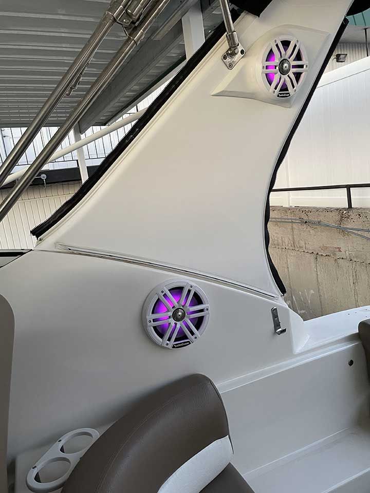 A boat with purple speakers on the side of it