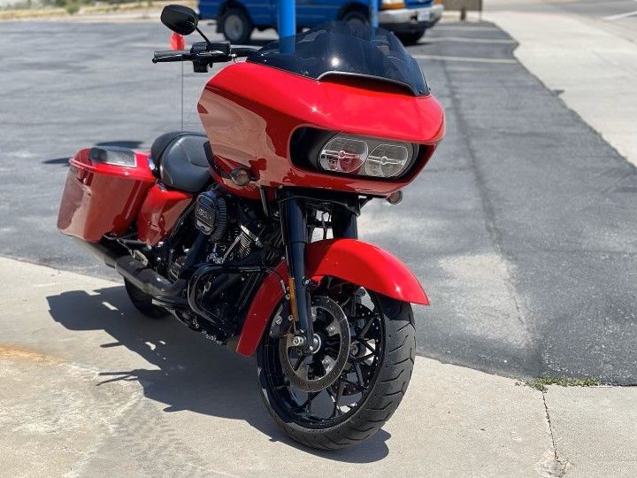 A red Harley-Davidson motorcycle is parked on the sidewalk