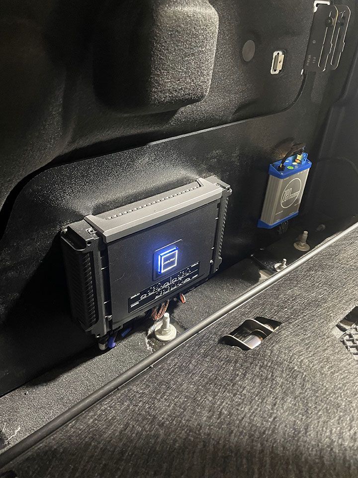 A car amplifier is sitting in the trunk of a car