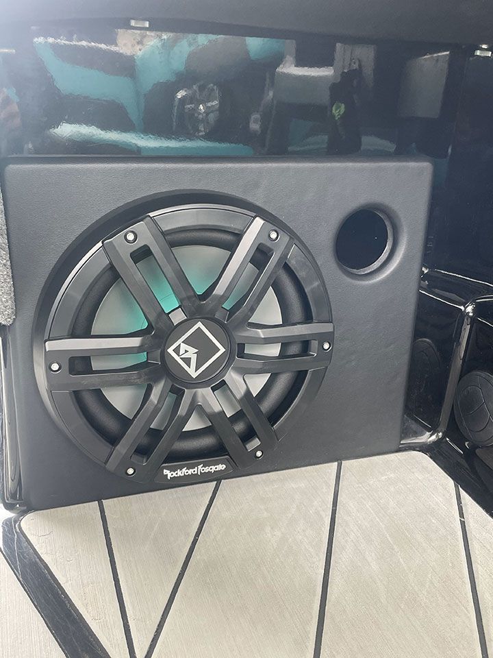 A black subwoofer is sitting on top of a table