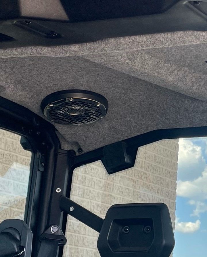 A close up of a speaker on the ceiling of a vehicle