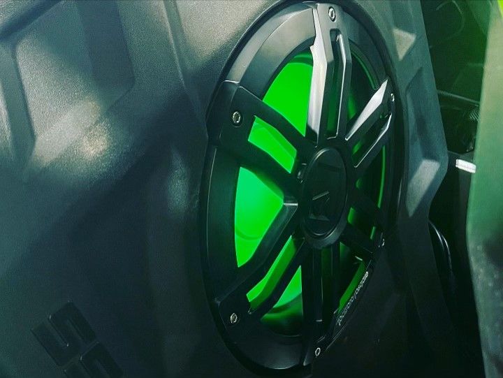 A close up of a speaker with a green light on it