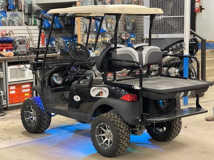 A black golf cart is parked in a garage