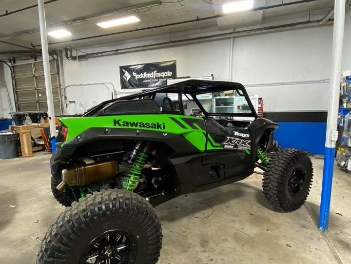 A Kawasaki ATV is parked in a garage