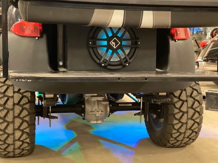 A golf cart with a speaker on the back of it