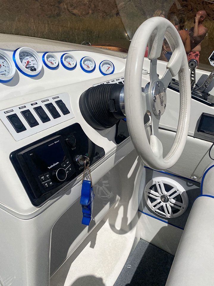 A white boat with a steering wheel and dashboard