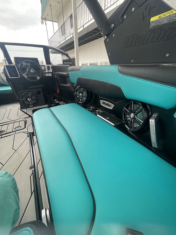 The inside of a boat with a blue seat and speakers