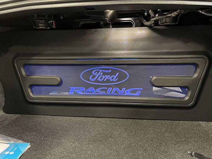 The trunk of a ford car has a ford racing logo on it