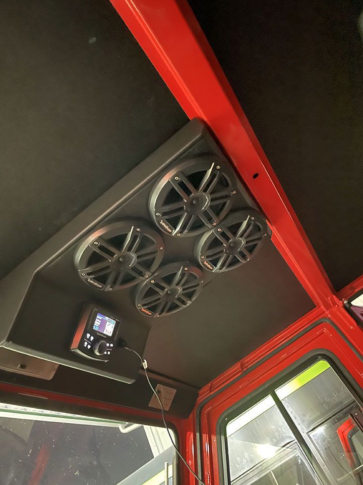 The inside of a red truck with speakers on the ceiling