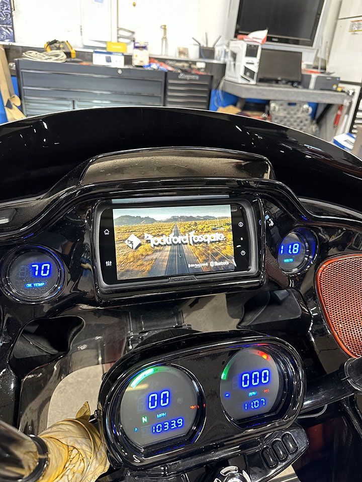 The dashboard of a motorcycle with a radio and a screen