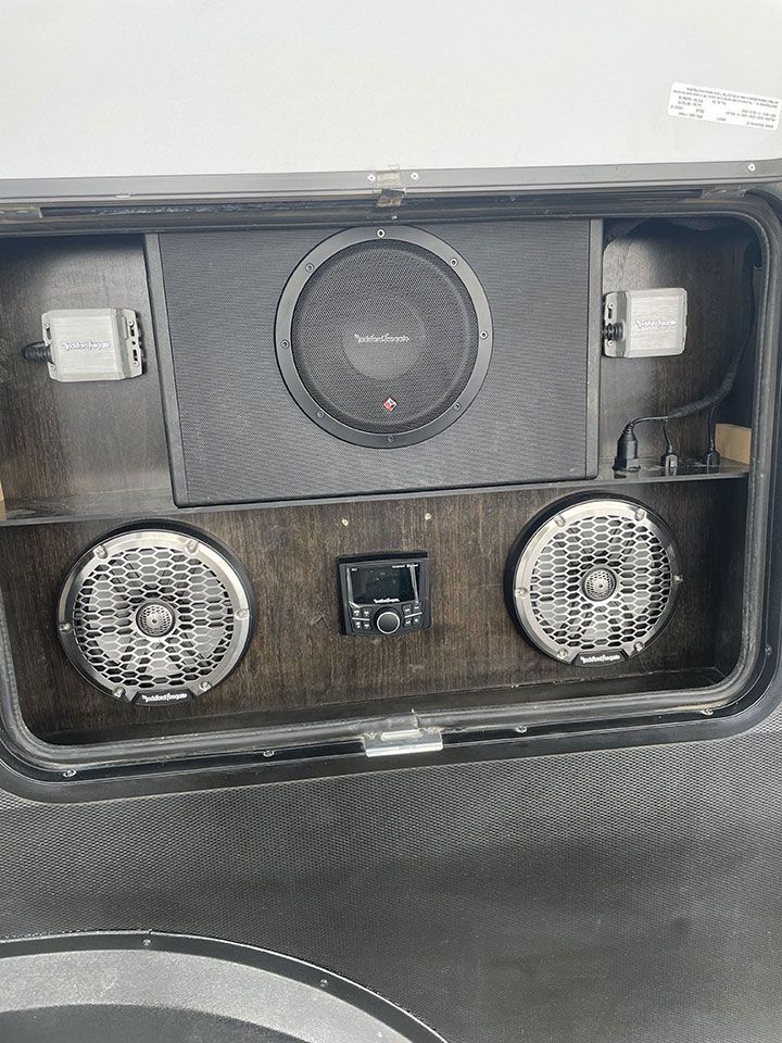 A subwoofer and speakers are installed in the back of a trailer