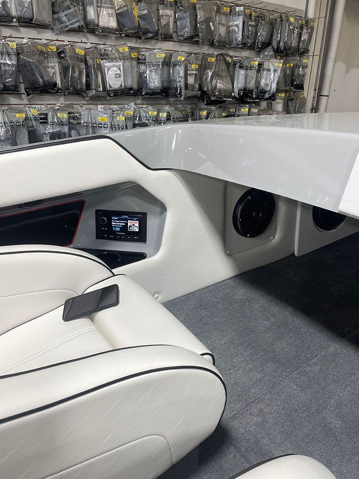 A boat with white seats and speakers in a store