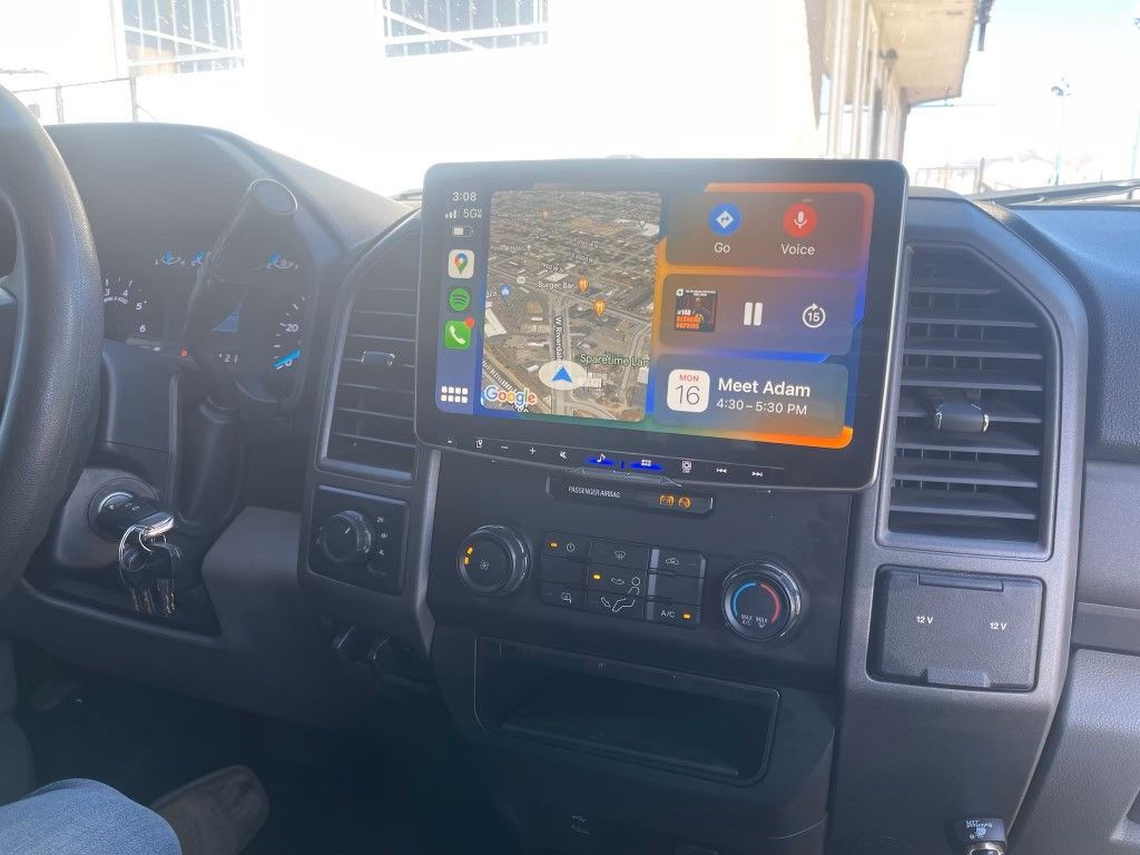 A person is sitting in a car with a tablet on the dashboard