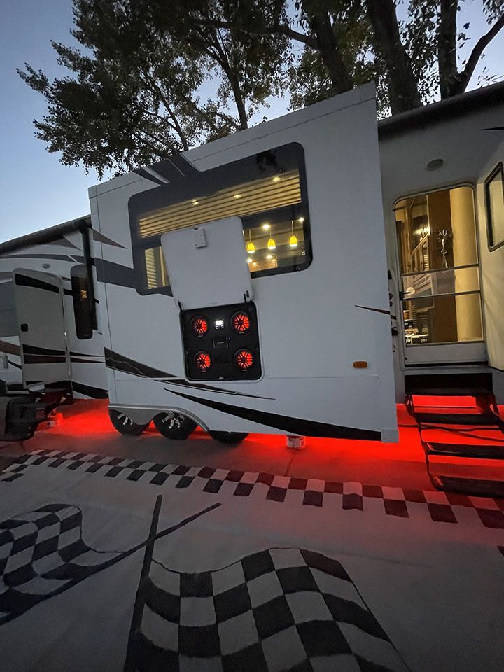 A RV is parked in a parking lot with a checkered flag on the ground