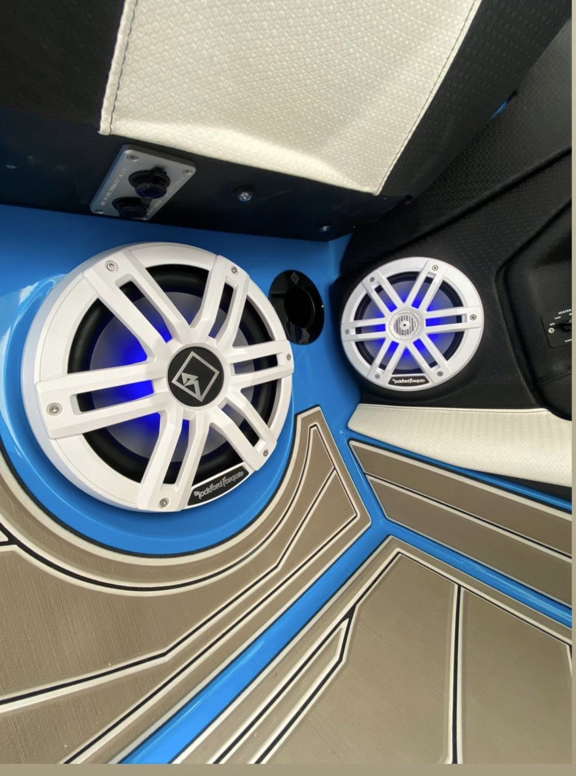 A pair of speakers on a boat with blue lights
