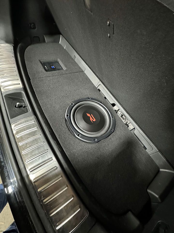 A subwoofer is sitting in the back of a car