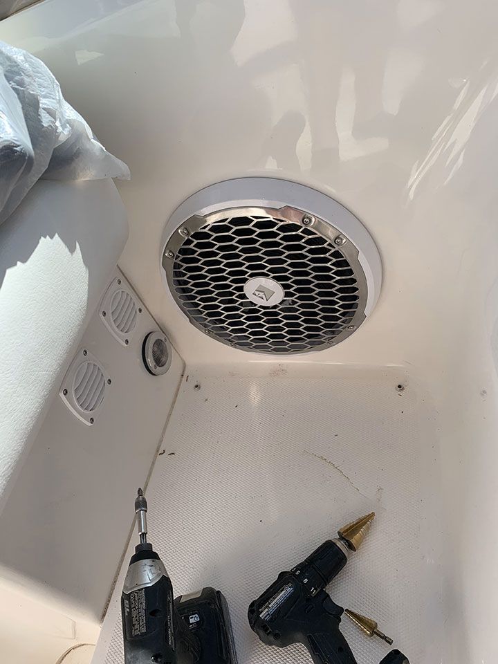 A fan is being installed on the ceiling of a boat