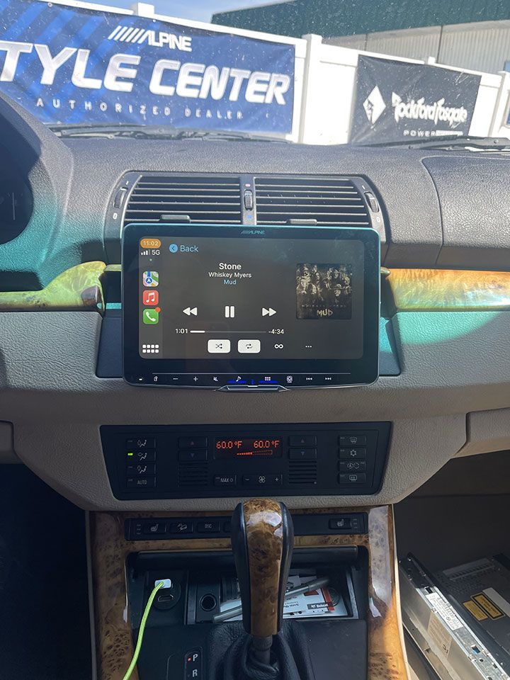 A car dashboard with an Alpine style center sign in the background