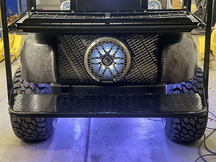 The front of a golf cart with a speaker on it