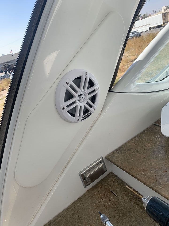 A speaker is being installed on the side of a boat