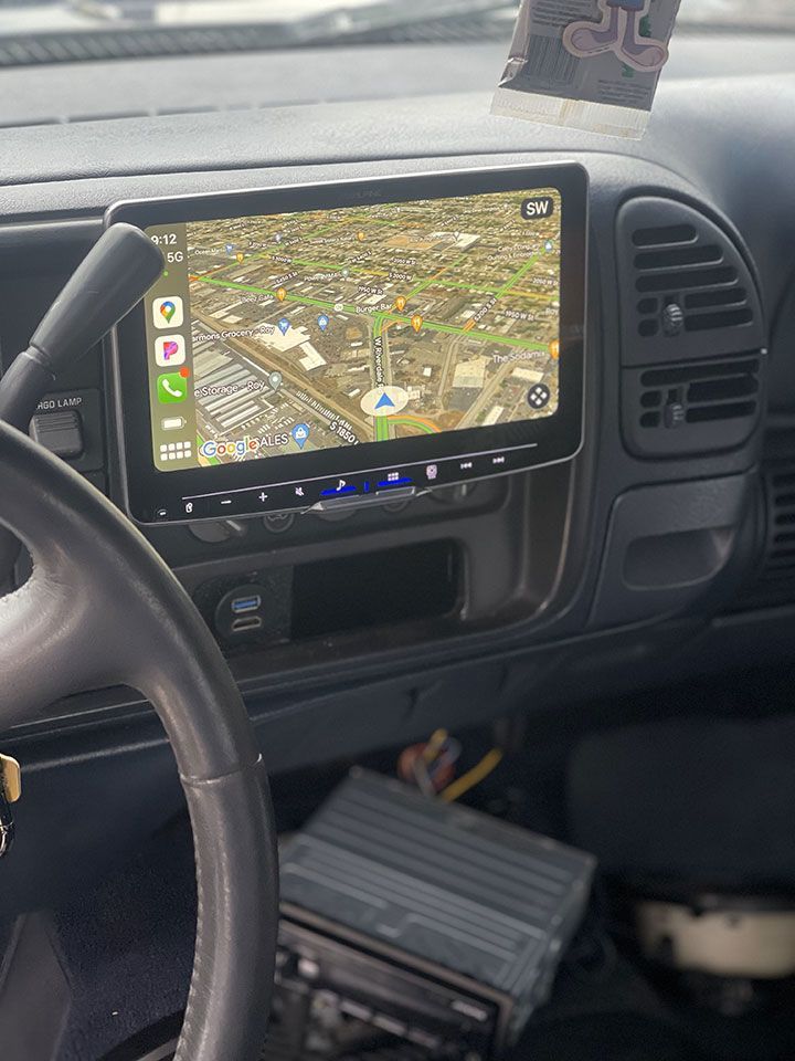 The inside of a car with a steering wheel and a navigation system