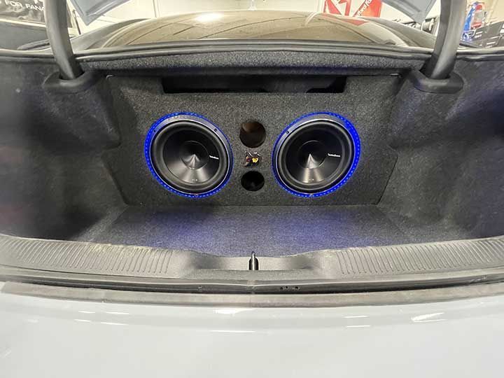 The trunk of a car with two speakers in it